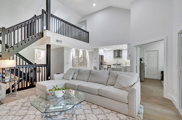 3704 Fairway Dr N, Jupiter, FL 33477 - living area featuring light wood-style floors, stairs, high vaulted ceiling, water heater, and recessed lighting