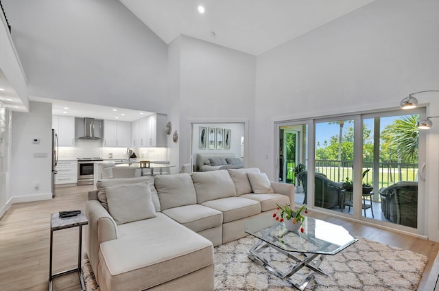 3704 Fairway Dr N, Jupiter, FL 33477 - living room featuring high vaulted ceiling, light wood-type flooring, and baseboards