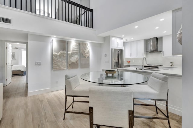 3704 Fairway Dr N, Jupiter, FL 33477 - dining room with baseboards, light wood-style floors, recessed lighting, and a towering ceiling