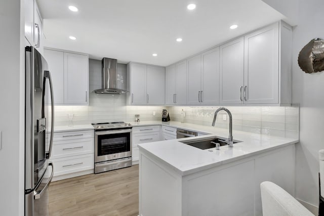 3704 Fairway Dr N, Jupiter, FL 33477 - kitchen featuring wall chimney range hood, stainless steel appliances, a sink, a peninsula, and backsplash