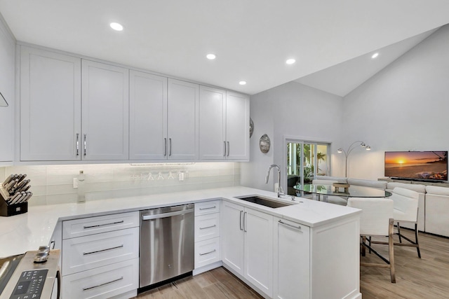 3704 Fairway Dr N, Jupiter, FL 33477 - kitchen with dishwasher, a sink, a peninsula, white cabinets, and decorative backsplash