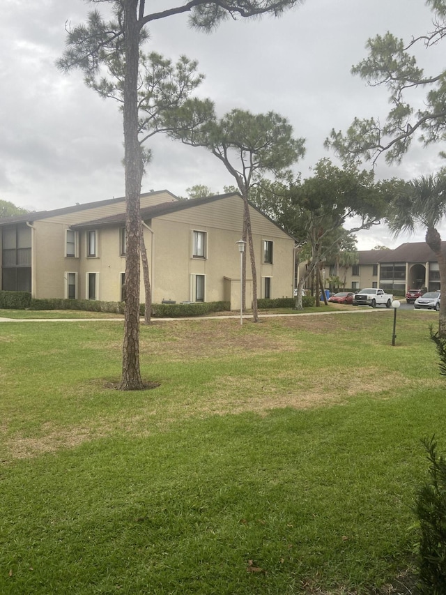719 Sunny Pine Way Unit G1, Greenacres, FL 33415 - view of property exterior with stucco siding and a yard