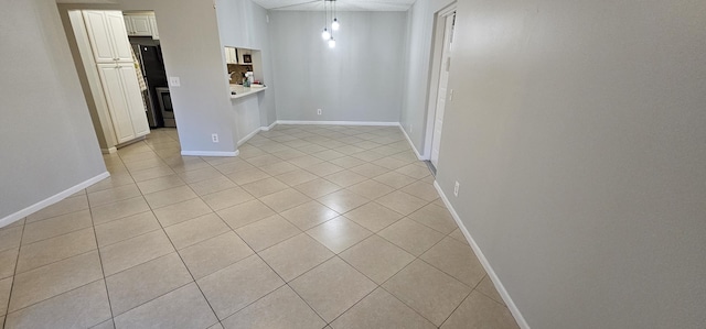 spare room featuring light tile patterned floors and baseboards