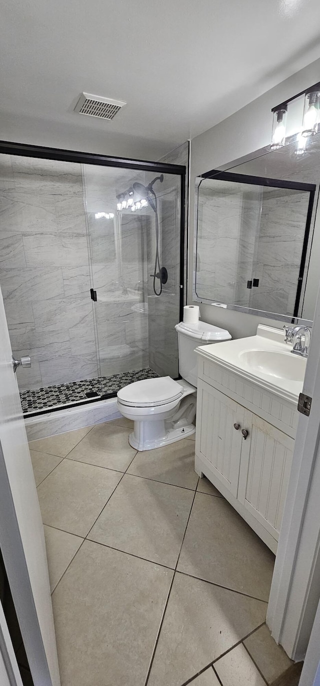 full bath with toilet, a shower stall, vanity, and tile patterned flooring