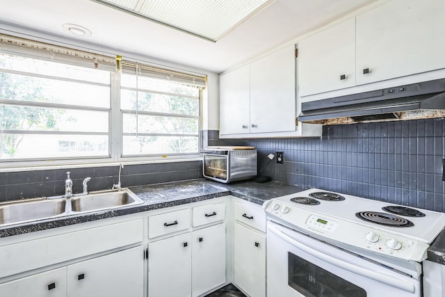 kitchen with white electric stove, under cabinet range hood, plenty of natural light, and white cabinetry