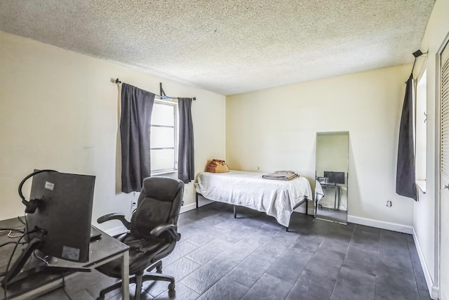 bedroom with a textured ceiling and baseboards