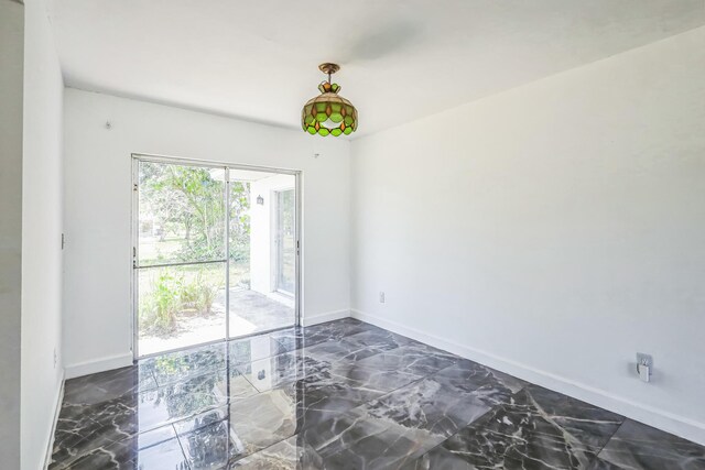 empty room with dark marble finish floors and baseboards