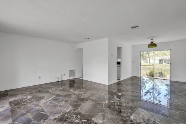 unfurnished living room with marble tiled flooring and baseboards