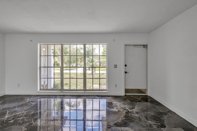 spare room featuring baseboards and marble tiled floors