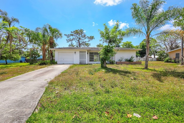ranch-style home with concrete driveway, an attached garage, stucco siding, and a front yard