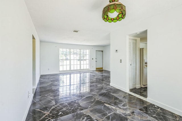 spare room with marble tiled flooring and baseboards