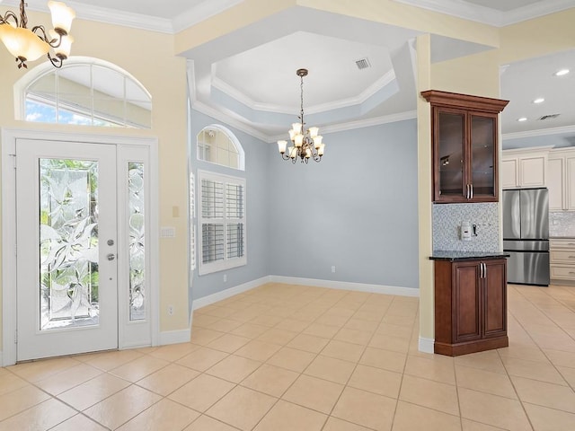 800 Alexandra Ave SW, Vero Beach, FL 32968 - foyer entrance featuring a chandelier, light tile patterned flooring, ornamental molding, and baseboards