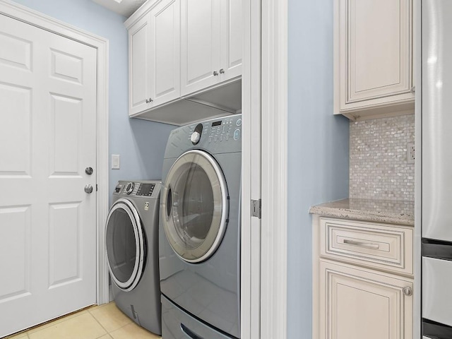 800 Alexandra Ave SW, Vero Beach, FL 32968 - laundry room with cabinet space, washing machine and dryer, and light tile patterned flooring