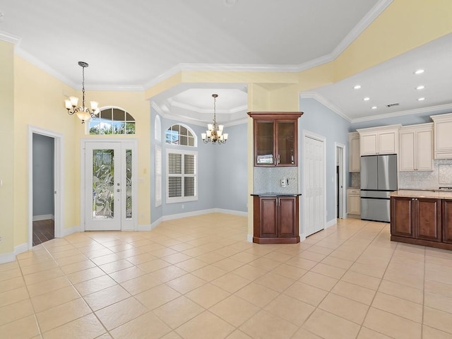 800 Alexandra Ave SW, Vero Beach, FL 32968 - kitchen featuring freestanding refrigerator, a chandelier, crown molding, tasteful backsplash, and light tile patterned flooring