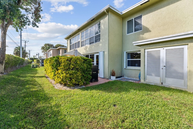 2520 Black Olive Blvd Unit 103, Delray Beach, FL 33445 - rear view of property with stucco siding and a yard