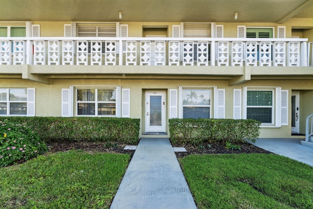 2520 Black Olive Blvd Unit 103, Delray Beach, FL 33445 - view of exterior entry with a balcony and stucco siding