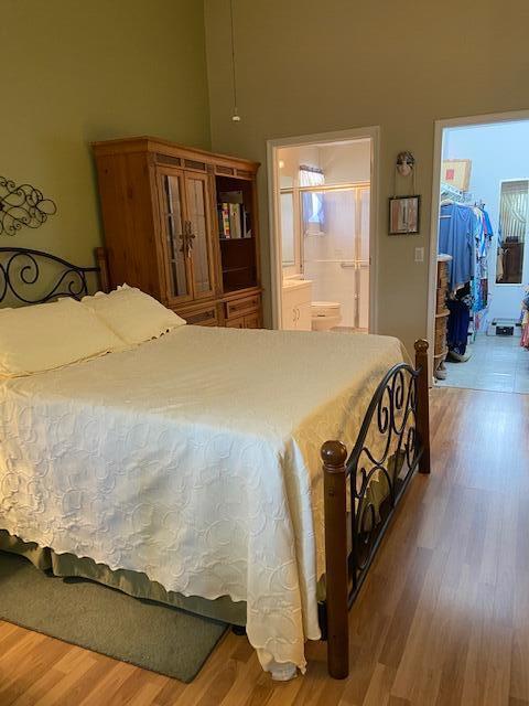 378 NW Sherry Ln, Port Saint Lucie, FL 34986 - bedroom with wood finished floors, a spacious closet, a closet, and ensuite bathroom