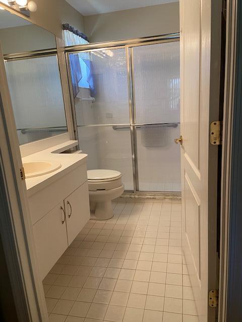 378 NW Sherry Ln, Port Saint Lucie, FL 34986 - full bath featuring tile patterned floors, vanity, a shower stall, and toilet