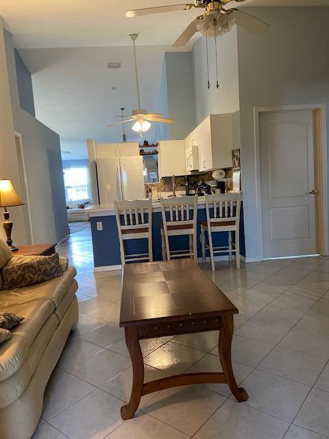 378 NW Sherry Ln, Port Saint Lucie, FL 34986 - living room with a towering ceiling, a ceiling fan, and light tile patterned flooring