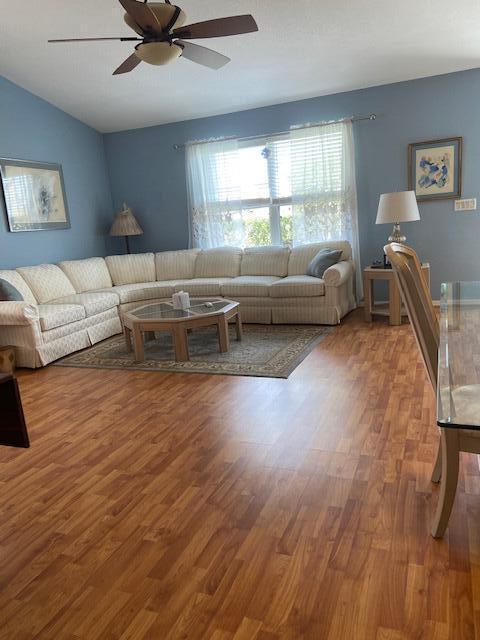378 NW Sherry Ln, Port Saint Lucie, FL 34986 - living room featuring ceiling fan, wood finished floors, and vaulted ceiling