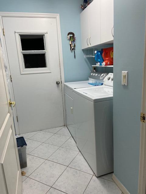 378 NW Sherry Ln, Port Saint Lucie, FL 34986 - laundry area with independent washer and dryer, cabinet space, and light tile patterned flooring