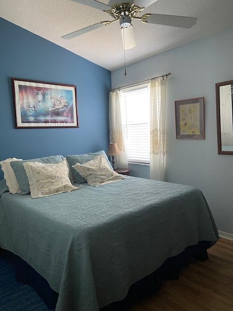 378 NW Sherry Ln, Port Saint Lucie, FL 34986 - bedroom with wood finished floors, a ceiling fan, baseboards, and vaulted ceiling