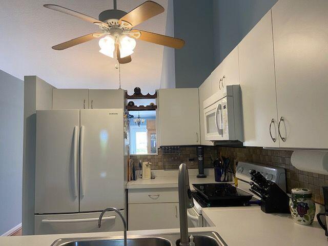 378 NW Sherry Ln, Port Saint Lucie, FL 34986 - kitchen with white appliances, light countertops, a ceiling fan, and tasteful backsplash