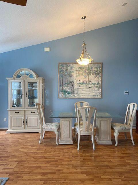 378 NW Sherry Ln, Port Saint Lucie, FL 34986 - dining area featuring wood finished floors, lofted ceiling, and baseboards
