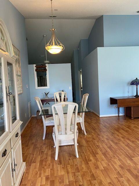 378 NW Sherry Ln, Port Saint Lucie, FL 34986 - dining area with high vaulted ceiling, light wood-style floors, and baseboards