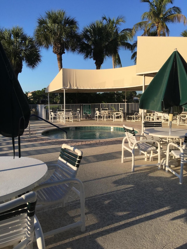 378 NW Sherry Ln, Port Saint Lucie, FL 34986 - community pool featuring a patio area and fence