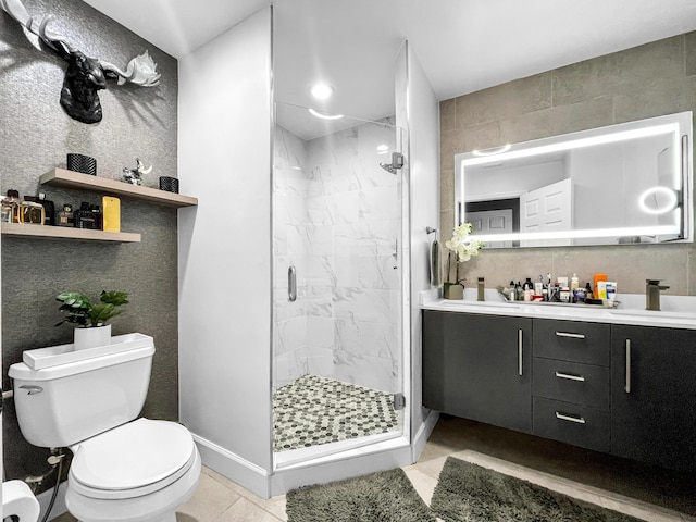 full bathroom with toilet, a marble finish shower, vanity, and tile walls