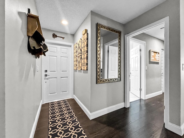 corridor featuring baseboards and dark wood-type flooring