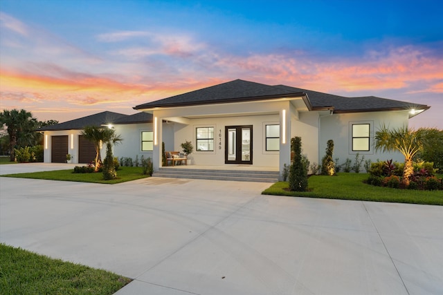 16149 73rd Ter N, West Palm Beach, FL 33418 - prairie-style house with a porch, driveway, stucco siding, a yard, and a garage