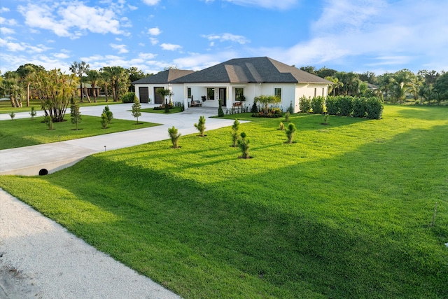16149 73rd Ter N, West Palm Beach, FL 33418 - view of front of property with driveway, a garage, a front lawn, and covered porch
