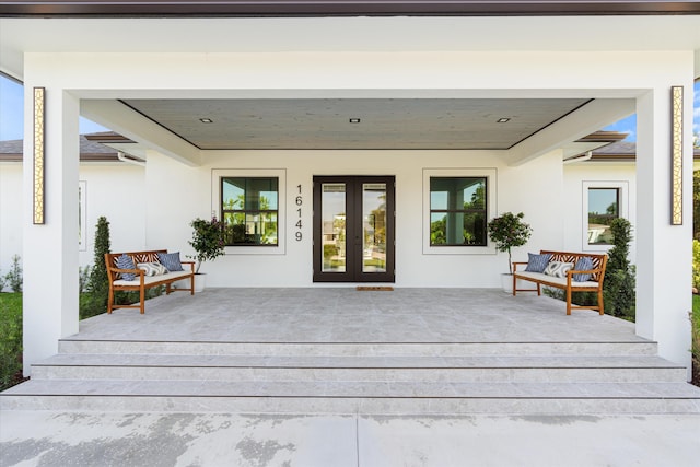 16149 73rd Ter N, West Palm Beach, FL 33418 - view of exterior entry featuring french doors, stucco siding, and a wooden deck