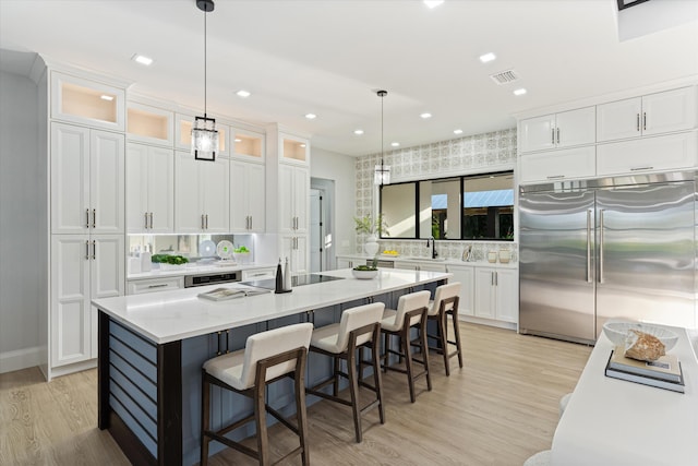 16149 73rd Ter N, West Palm Beach, FL 33418 - kitchen featuring stainless steel built in refrigerator, light wood-style floors, white cabinetry, a sink, and backsplash