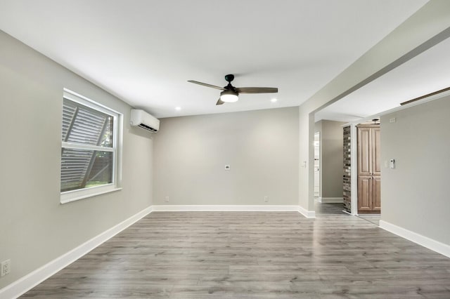825 Northern Dr, Lake Park, FL 33403 - empty room featuring an AC wall unit, a ceiling fan, wood finished floors, baseboards, and recessed lighting
