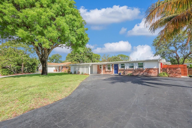 825 Northern Dr, Lake Park, FL 33403 - ranch-style home featuring brick siding, driveway, a front lawn, and a carport