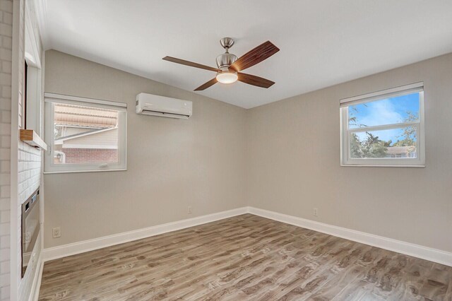 825 Northern Dr, Lake Park, FL 33403 - empty room featuring an AC wall unit, wood finished floors, a ceiling fan, and baseboards