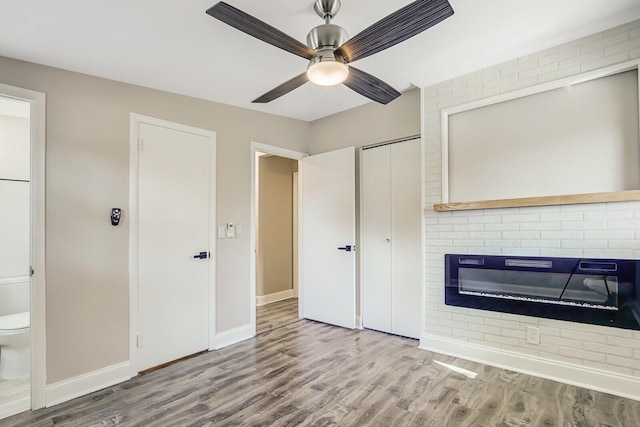 825 Northern Dr, Lake Park, FL 33403 - unfurnished living room featuring a fireplace, wood finished floors, ceiling fan, and baseboards