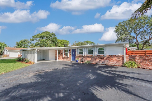 825 Northern Dr, Lake Park, FL 33403 - ranch-style house with brick siding, driveway, and an attached carport