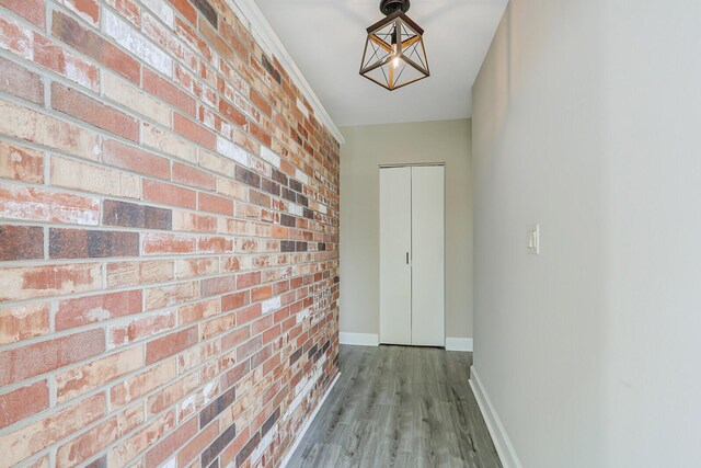 825 Northern Dr, Lake Park, FL 33403 - hallway featuring brick wall, baseboards, and wood finished floors