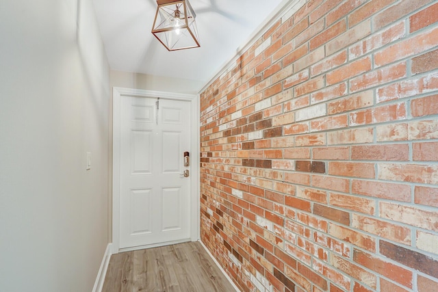825 Northern Dr, Lake Park, FL 33403 - entryway with brick wall, baseboards, and light wood finished floors