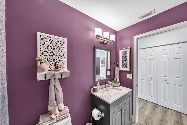 bathroom featuring wood finished floors, vanity, and toilet