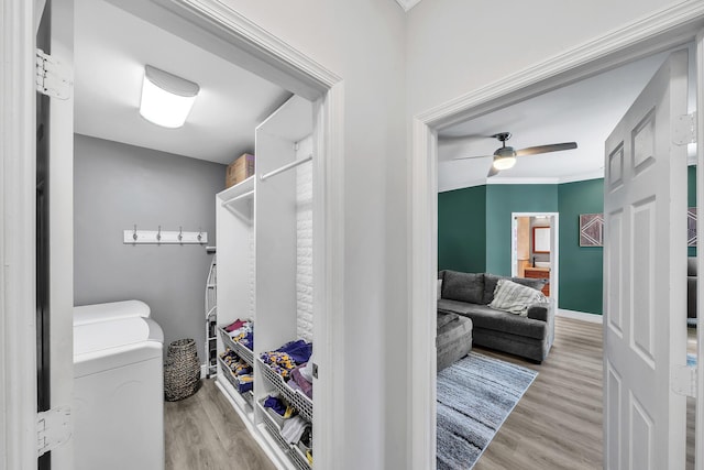 spacious closet featuring wood finished floors, washing machine and dryer, and ceiling fan