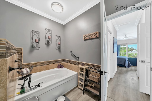 bathroom with ornamental molding, wood finished floors, a tub with jets, connected bathroom, and tile walls