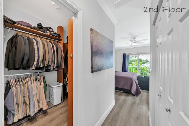 hall featuring ornamental molding, wood finished floors, and baseboards