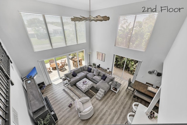 living room featuring a high ceiling, wood finished floors, and plenty of natural light