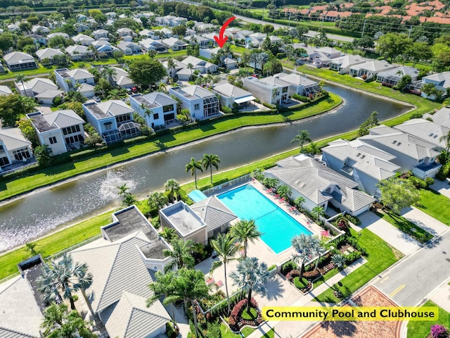 aerial view of residential area featuring a nearby body of water and a pool
