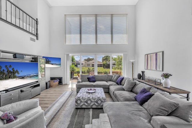 living room with a high ceiling and wood finished floors
